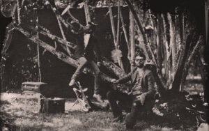 Image en sépia d'un homme sur une branche avec une trompette et d'un homme assis avec une canne.